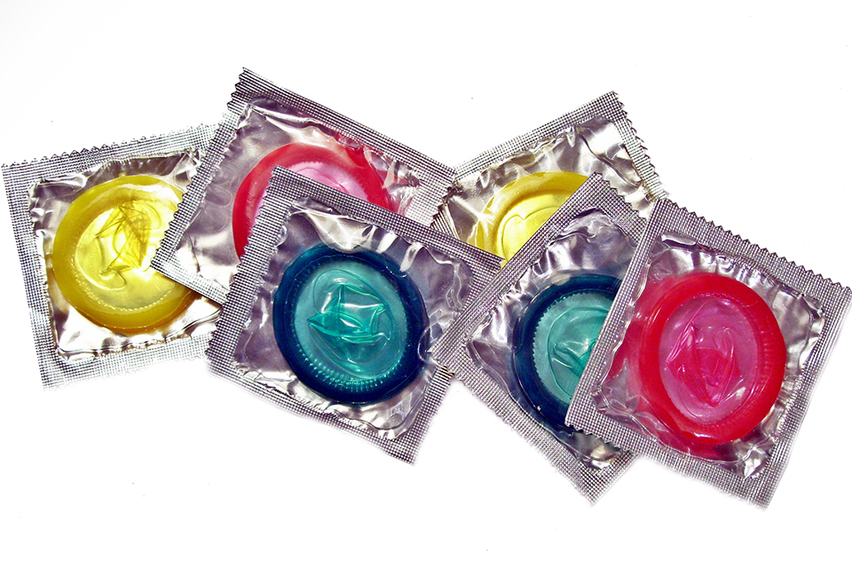 Several colorful condoms visible through clear packaging.