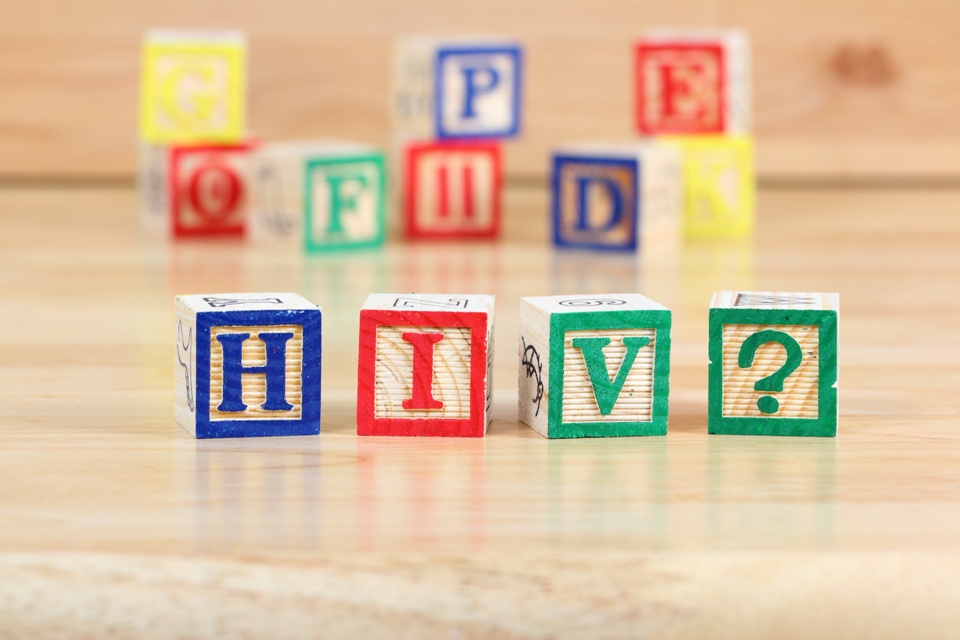 Colorful lettered baby blocks with some spelling out "H I V ?"