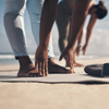 Two women stretching at the beach.