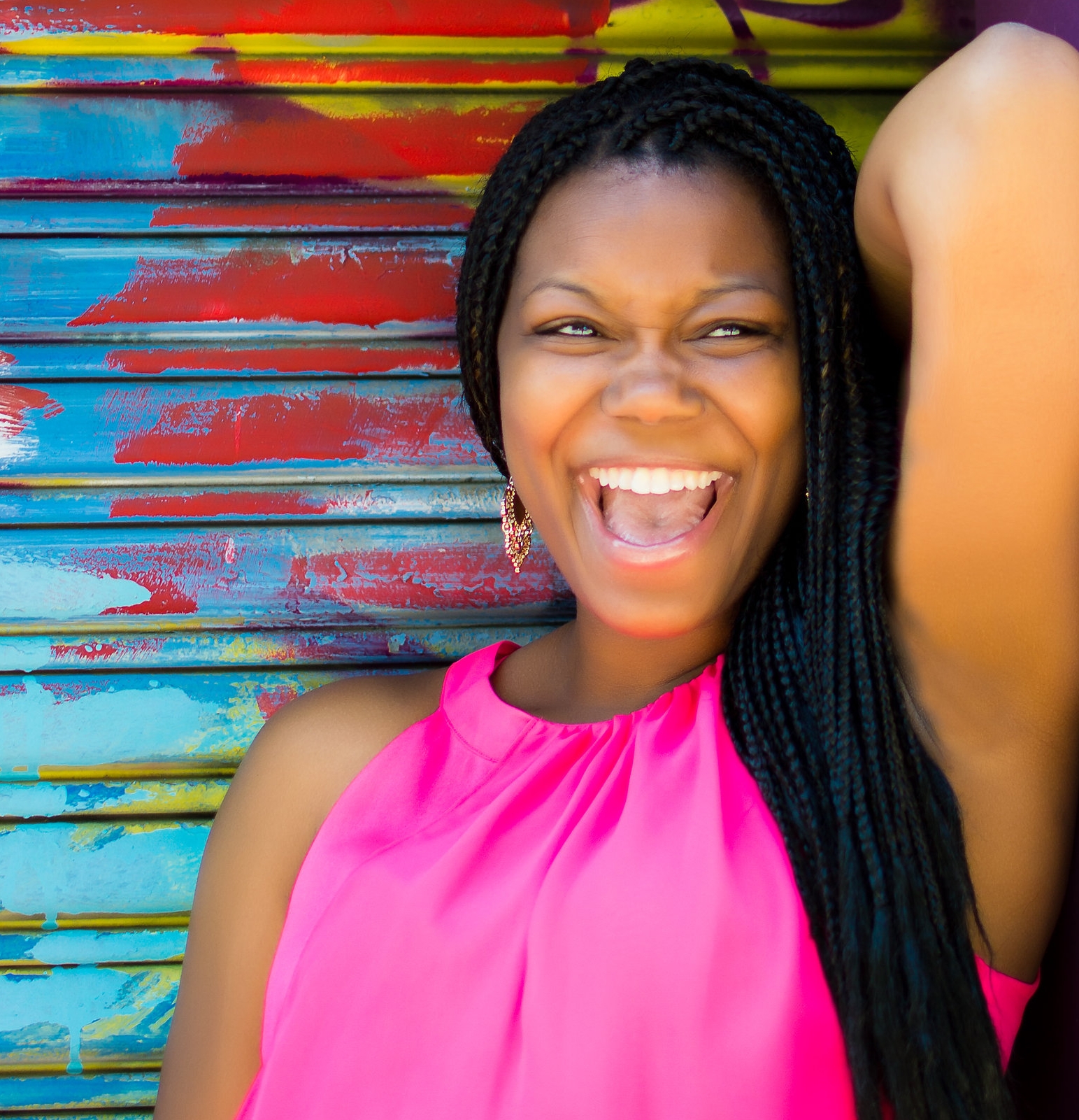 Masonia Traylor, smiling, standing in front of a colorful wall.