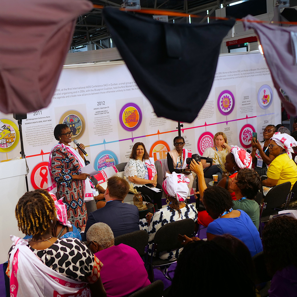 Woman speaking with microphone to a group of people at ICW.