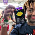 Eliane (HIVstigmafighter) holding up a badge that reads "PrEP diversity".