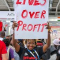 A Girl Like Me blogger Eliane (HIVstigmafighter) holding a sign that says "Lives over profits".