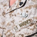 Close-up of shirt of person wearing brown camouflage US Marines uniform.