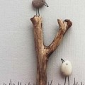 Craft project using a stick as a tree and two stones as birds.