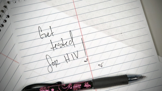 Page torn out of notebook with handwritten note that reads "Get tested for HIV!".