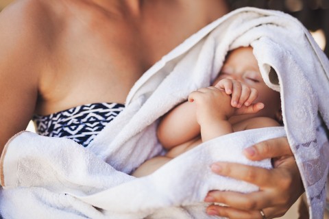 Close-up of swaddled infant being held.