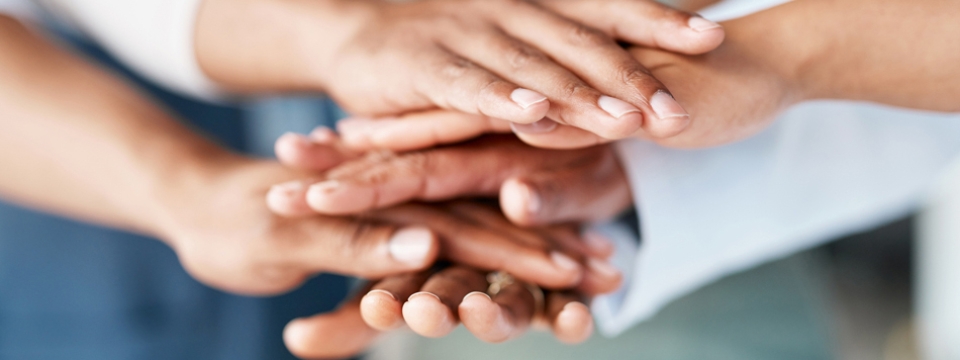 Hands stacked atop one another representing solidarity and support.